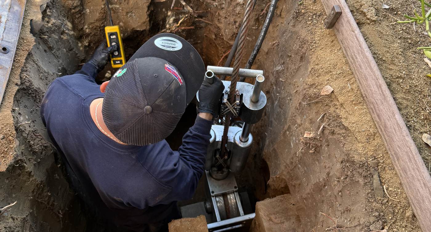 Best Coast Plumbing technician working on a drain line at an excavated cleanout