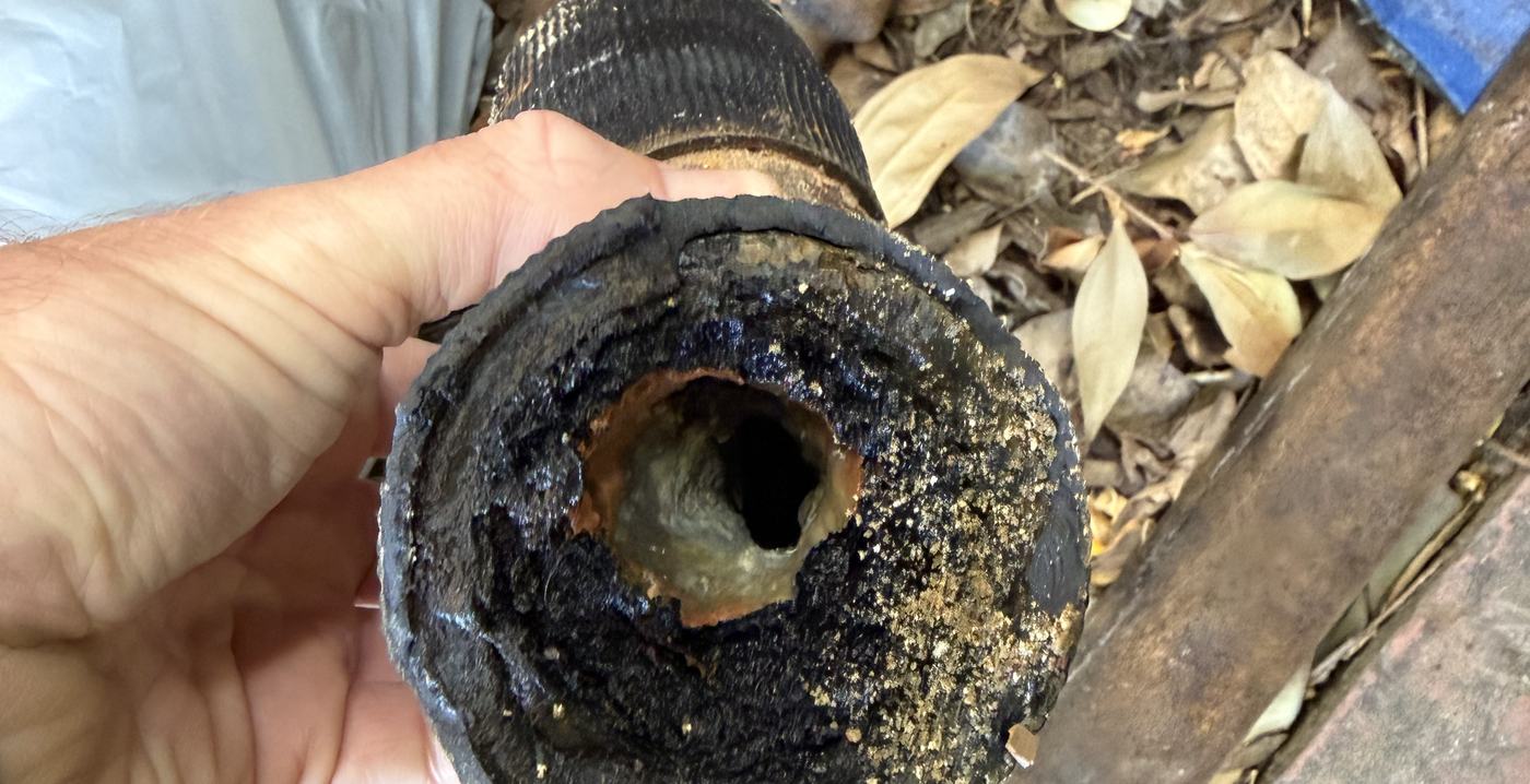 Corroded drain line removed from a Conejo Valley home, nearly closed off by internal buildup