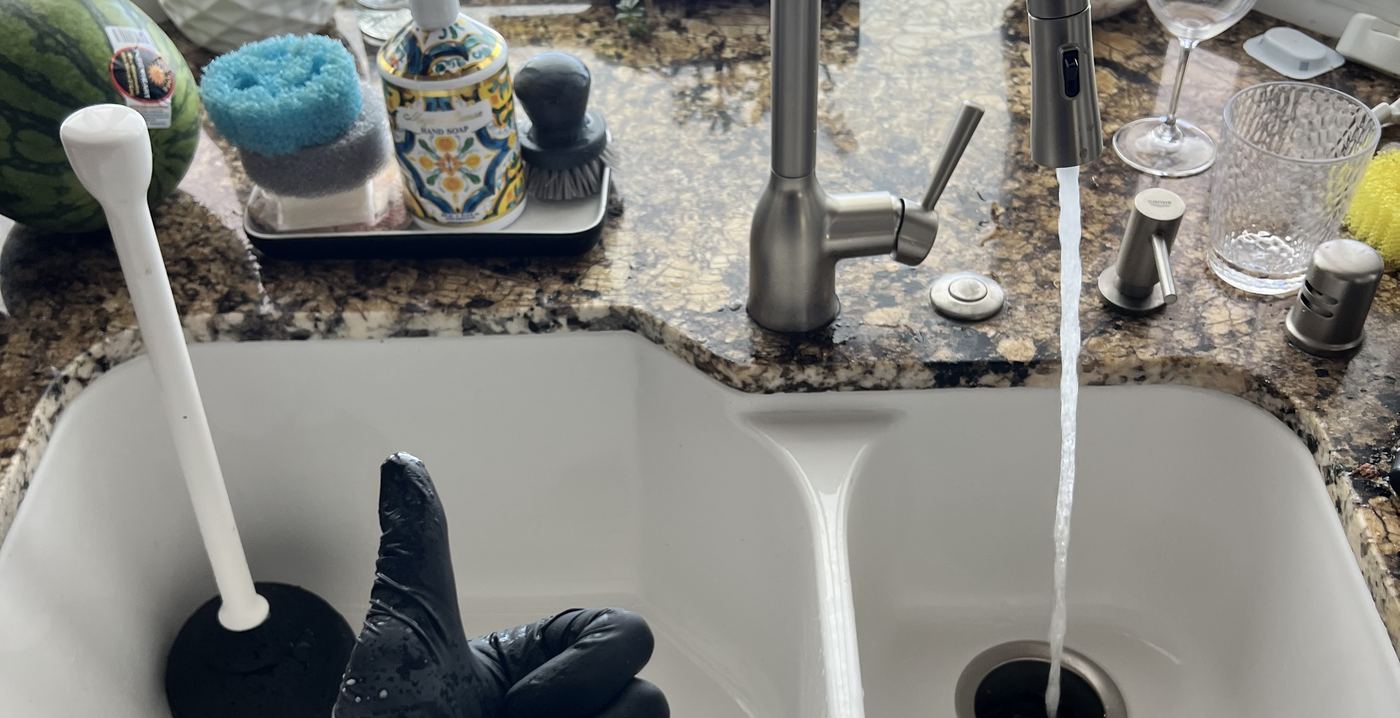 Best Coast Plumbing clearing a kitchen sink drain during a service call