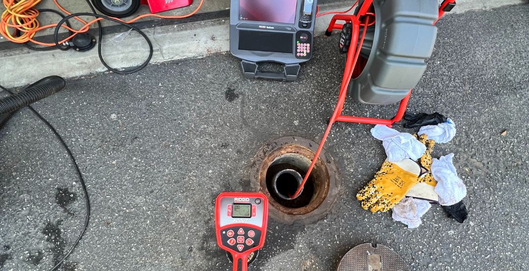 Best Coast Plumbing sewer camera and drain machine staged at a cleanout during a sewer inspection