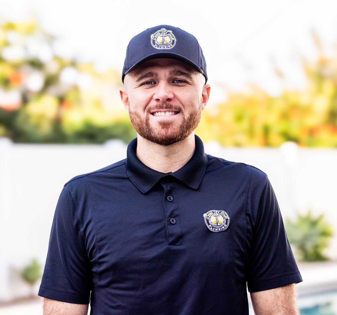 Brendan Lee, founder of Best Coast Plumbing, smiling in his branded uniform