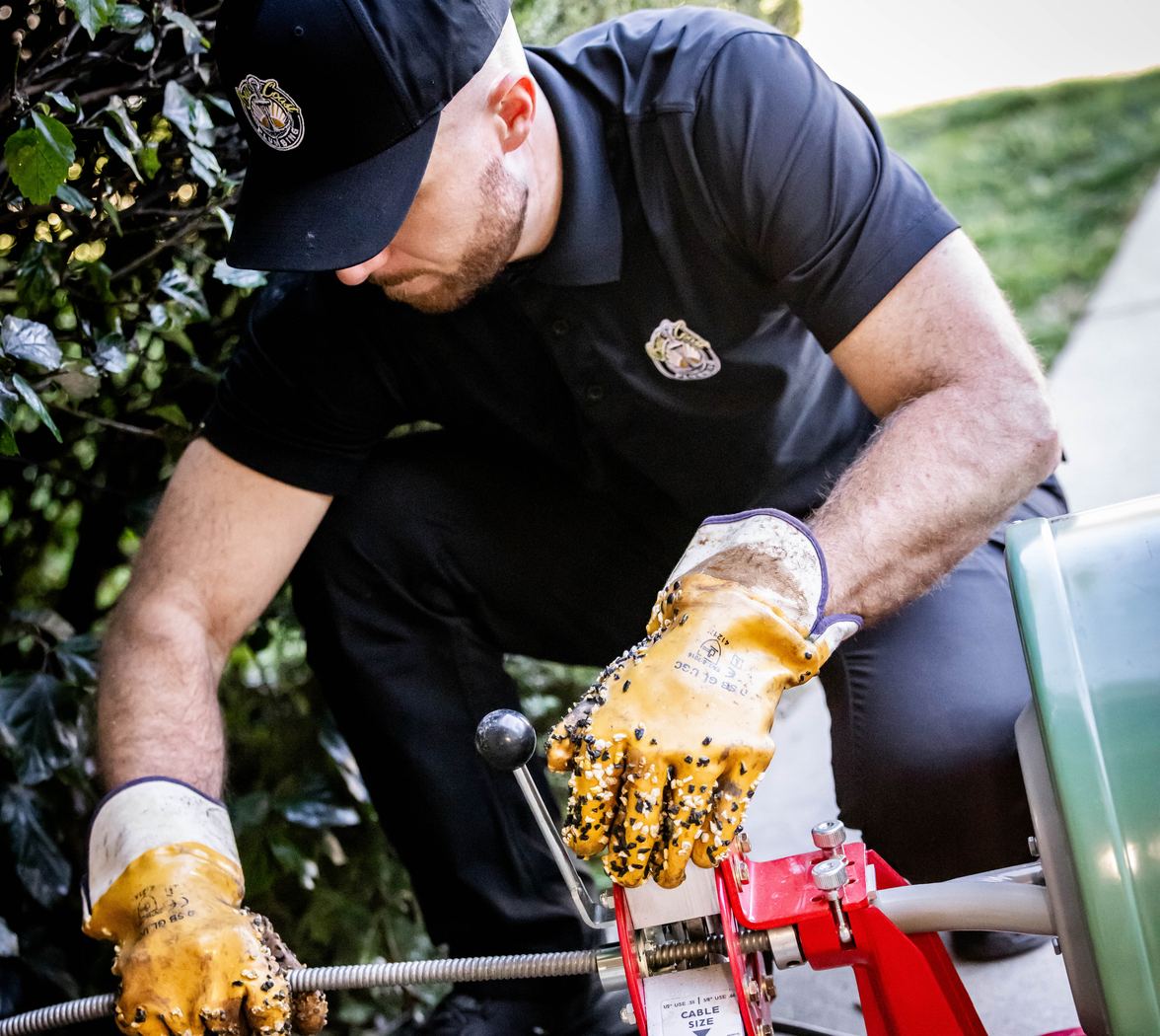 Best Coast Plumbing tech feeding the drain cable during a professional drain cleaning
