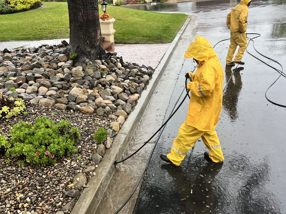 Best Coast Plumbing crew hydro jetting a flooded storm drain line during a rain storm