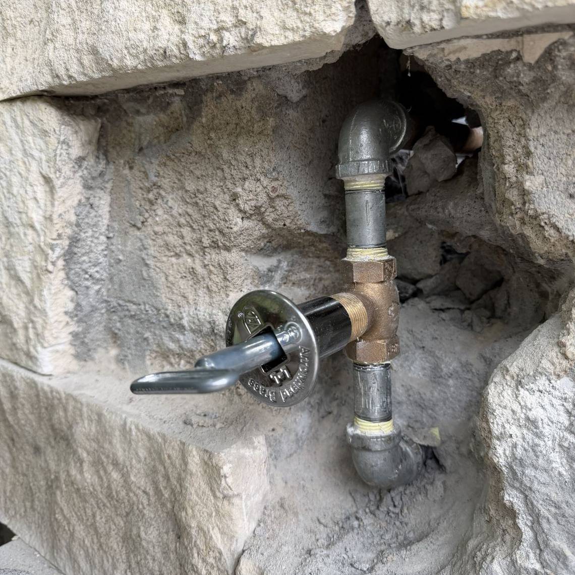 Fire pit gas key valve and new gas line installed in a stone wall by Best Coast Plumbing